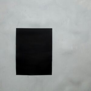 Rectangular creative black mock up poster with copy space hanging on empty gray wall in light room of modern studio